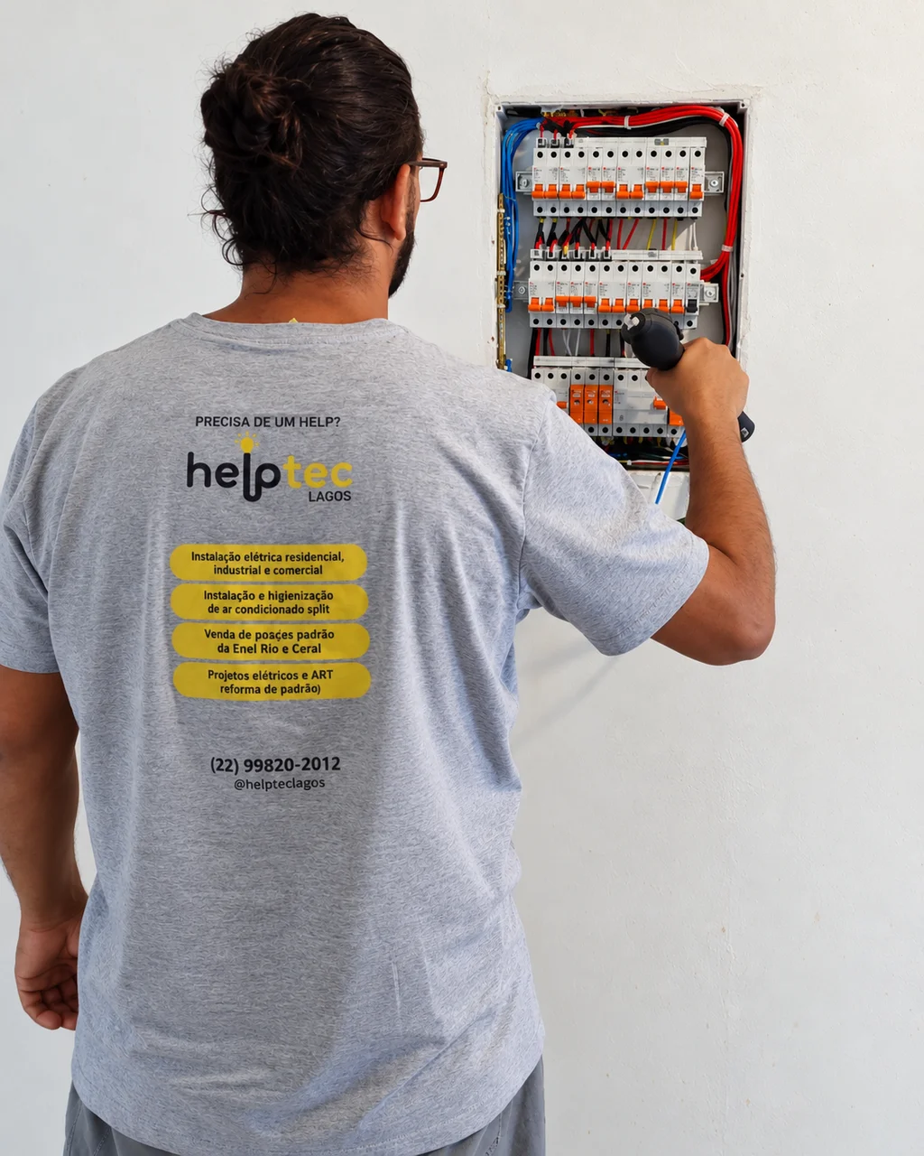 Profissional da Helptec Lagos trabalhando em um quadro de disjuntores
