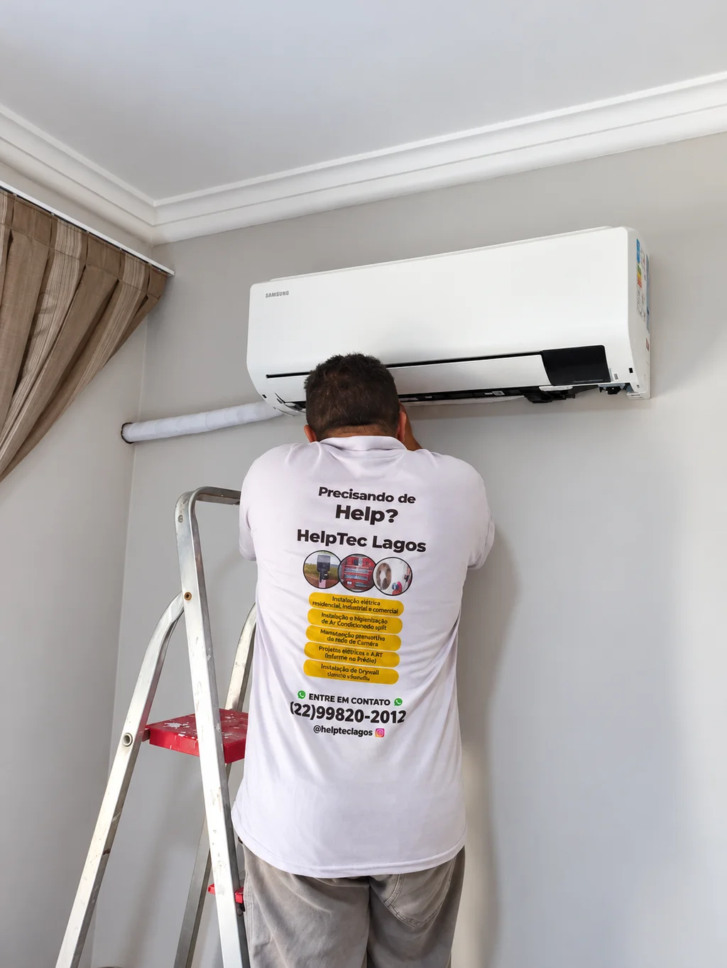 Profissional da Helptec Lagos realizando atendimento em ar-condicionado split